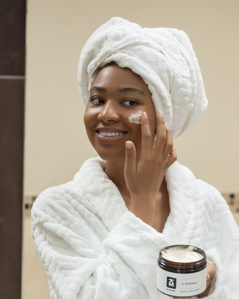 Mujer aplicándose crema facial frente al espejo