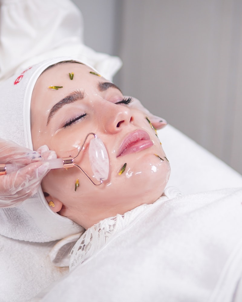 Especialista con guantes aplicando un tratamiento facial